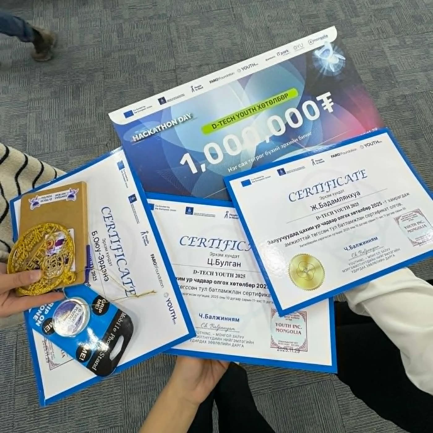Certificates and a one-million-tugrik prize award held in hand