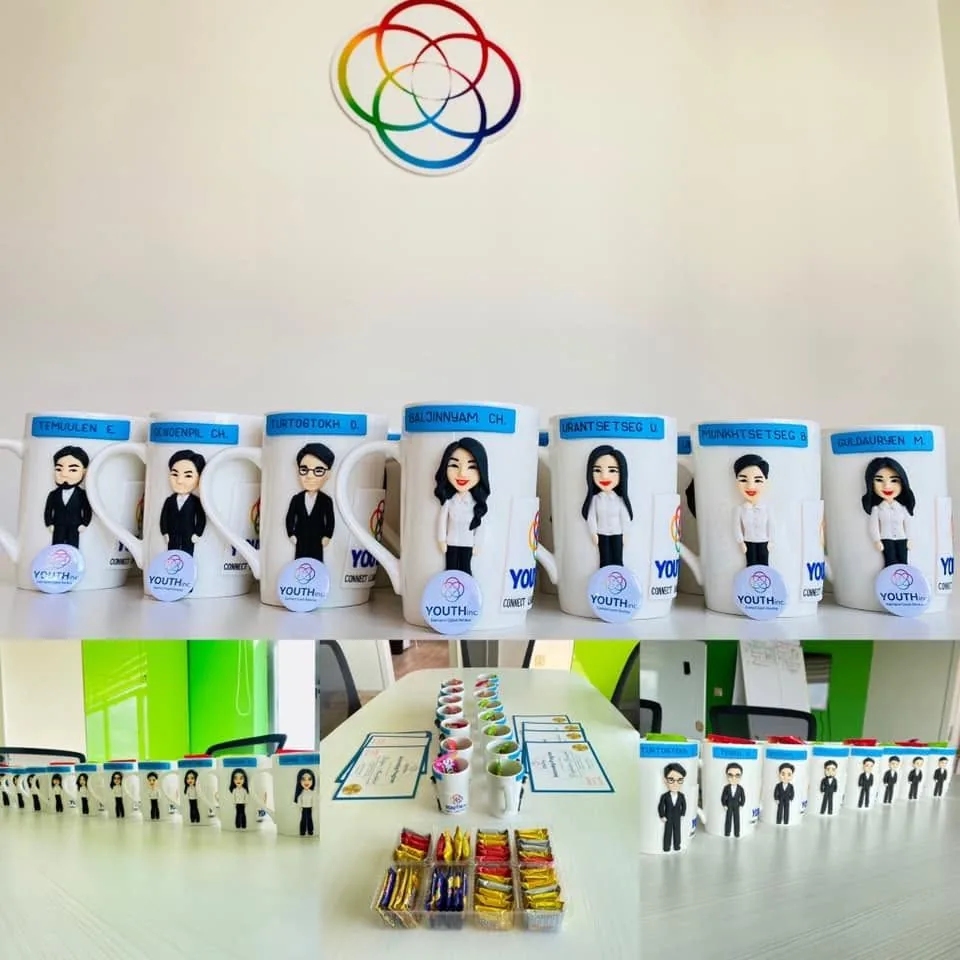 Leaving mugs modelled as each intern, name labels on the rims, under the YOUTHinc rosette