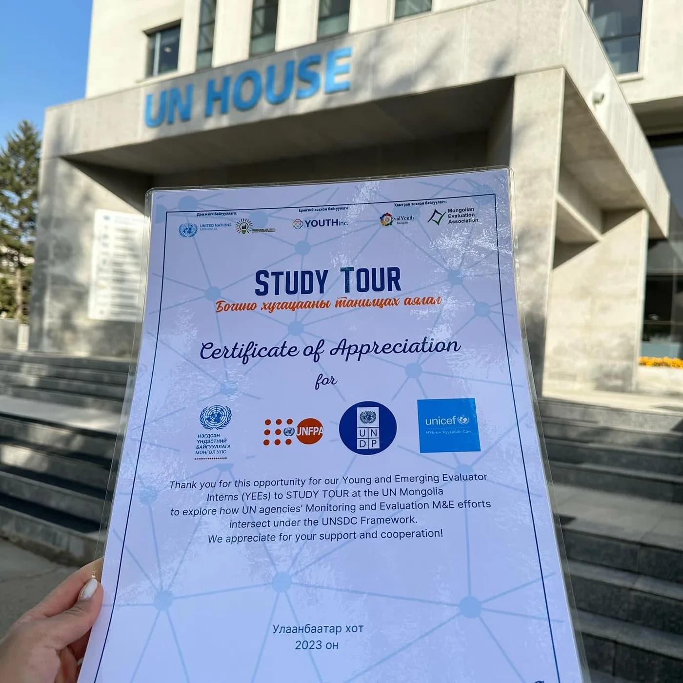 Study Tour certificate of appreciation held up outside UN House in Ulaanbaatar