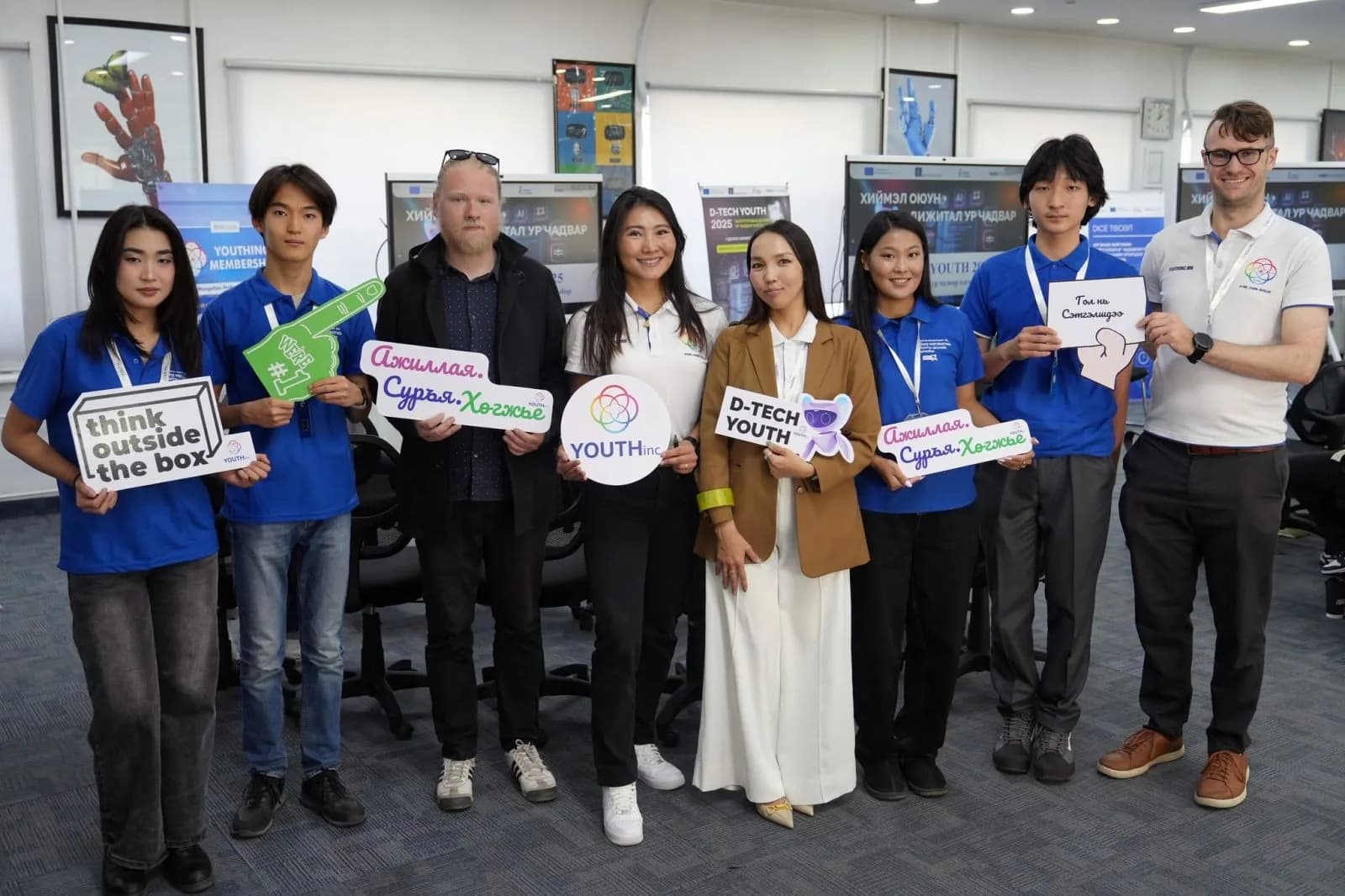 D-Tech Youth participants and mentors holding the programme's signs